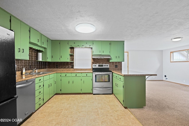 kitchen featuring a textured ceiling, green cabinets, stainless steel appliances, and backsplash