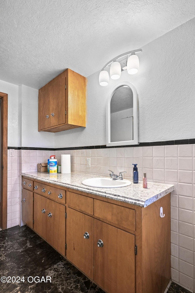 bathroom featuring vanity, tile walls, backsplash, and a textured ceiling