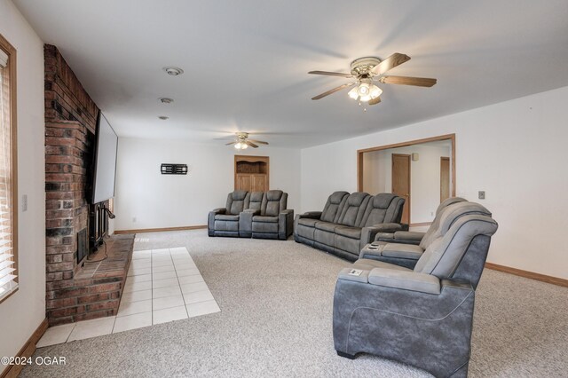 living room featuring carpet, a fireplace, baseboards, and a ceiling fan