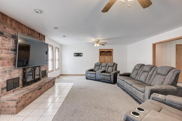 living room with light tile patterned floors, light colored carpet, visible vents, a ceiling fan, and a brick fireplace