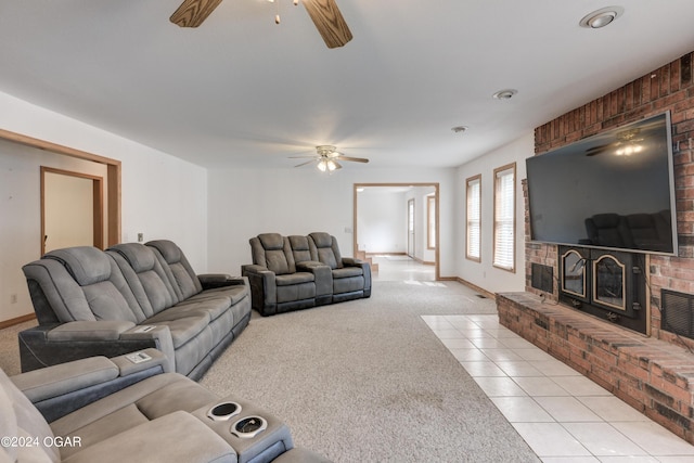 living room with light tile patterned floors, light carpet, a fireplace, a ceiling fan, and baseboards