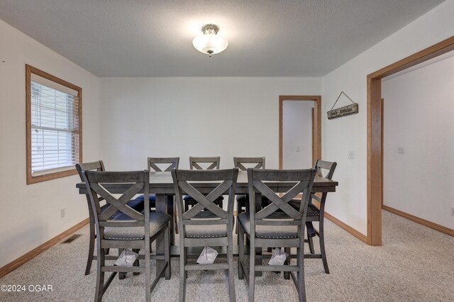 dining space featuring visible vents, baseboards, and light colored carpet