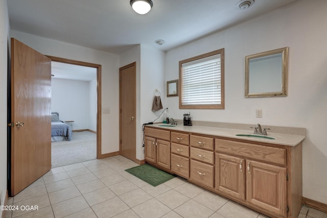 full bathroom with baseboards, double vanity, a sink, and tile patterned floors