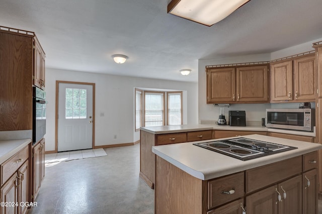 kitchen featuring concrete flooring, black appliances, a peninsula, and light countertops