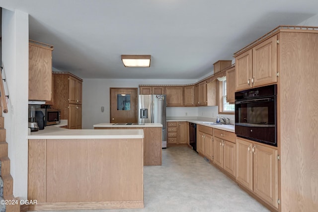 kitchen featuring a peninsula, light countertops, light brown cabinetry, black appliances, and a sink