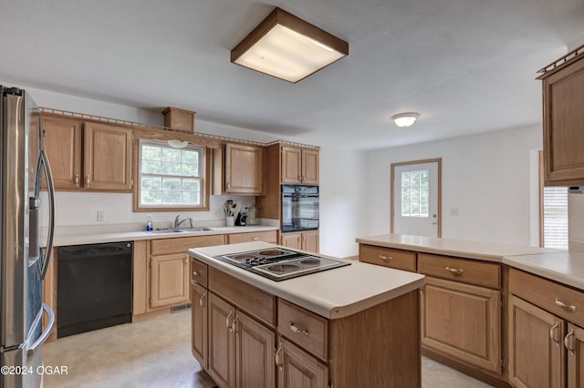 kitchen featuring black appliances, light countertops, and a healthy amount of sunlight