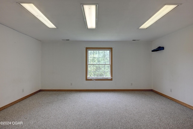 unfurnished room featuring carpet floors, visible vents, and baseboards