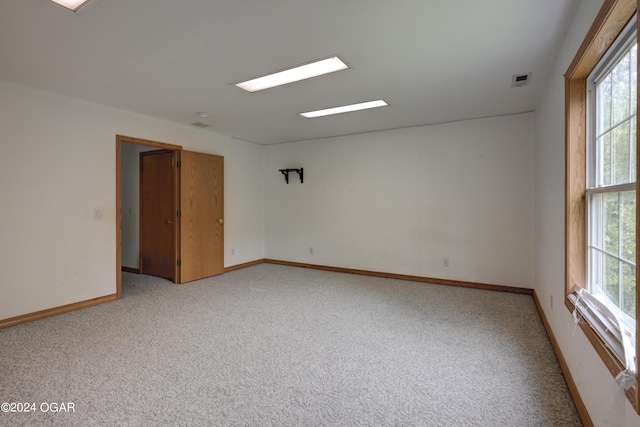 unfurnished room featuring visible vents, baseboards, and light colored carpet