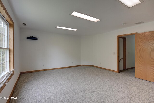 spare room with light carpet, visible vents, and baseboards