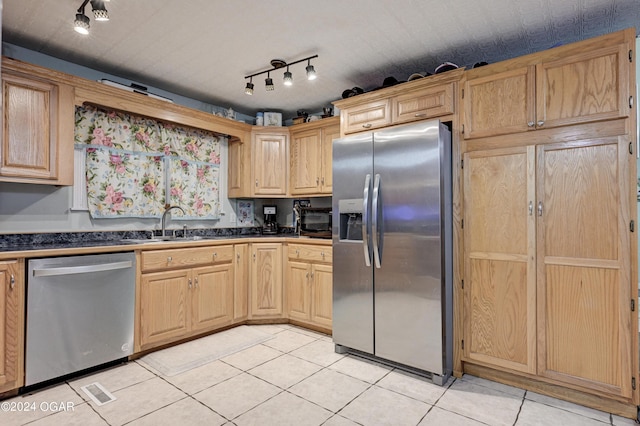 kitchen with appliances with stainless steel finishes, sink, light brown cabinetry, and light tile patterned flooring