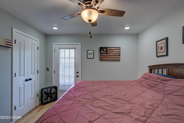 bedroom featuring ceiling fan, light hardwood / wood-style floors, and a textured ceiling