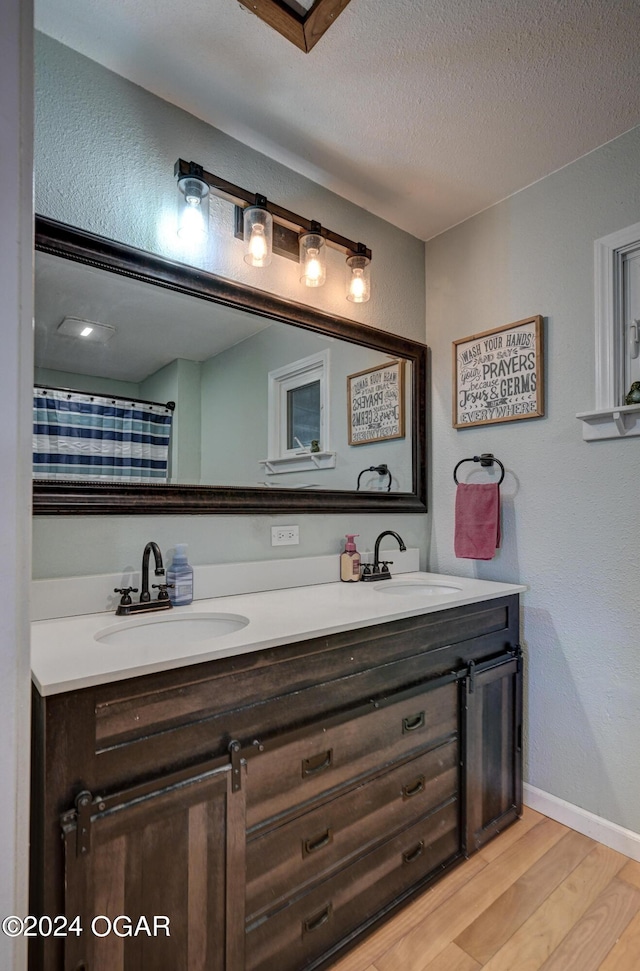 bathroom featuring a textured ceiling, vanity, and hardwood / wood-style floors