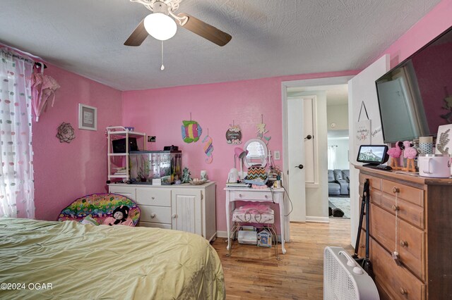 bedroom featuring a textured ceiling, ceiling fan, and hardwood / wood-style flooring