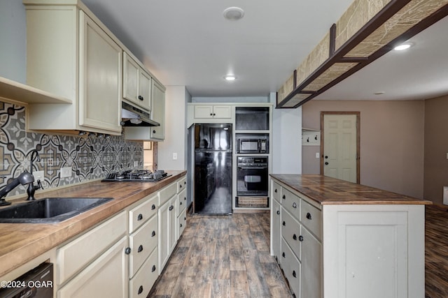 kitchen featuring black appliances, light hardwood / wood-style floors, sink, and wooden counters