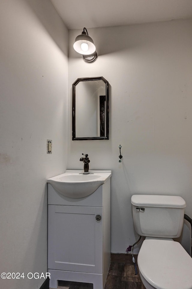 bathroom featuring vanity, toilet, and hardwood / wood-style flooring