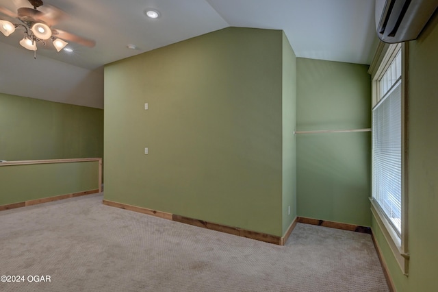 unfurnished room with light carpet, lofted ceiling, a wall unit AC, and ceiling fan