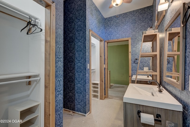 bathroom featuring ceiling fan, vaulted ceiling, and vanity