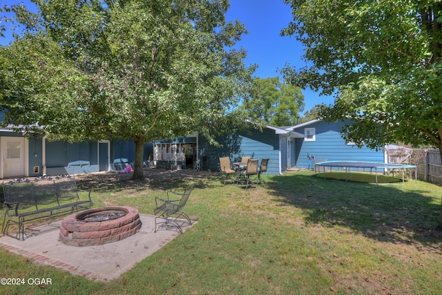 view of yard with an outdoor fire pit and a trampoline