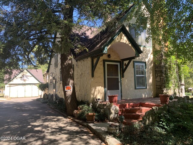 view of front of home with a garage and an outbuilding