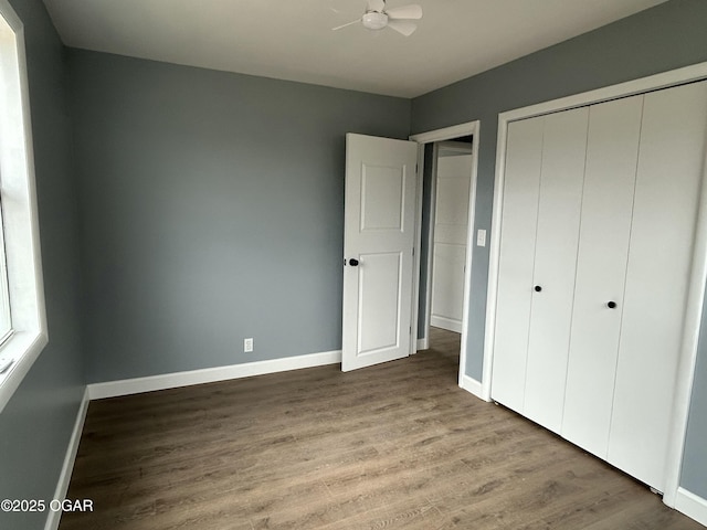 unfurnished bedroom featuring a closet, baseboards, and wood finished floors