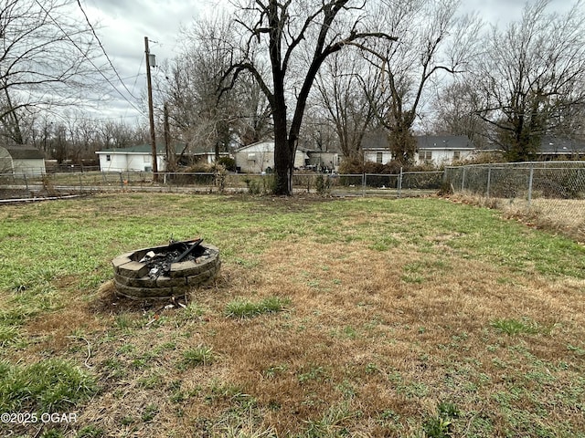 view of yard with a fire pit and fence