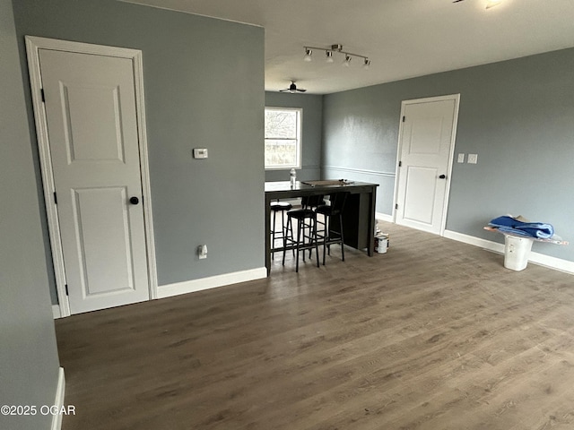 dining area with rail lighting, baseboards, and wood finished floors