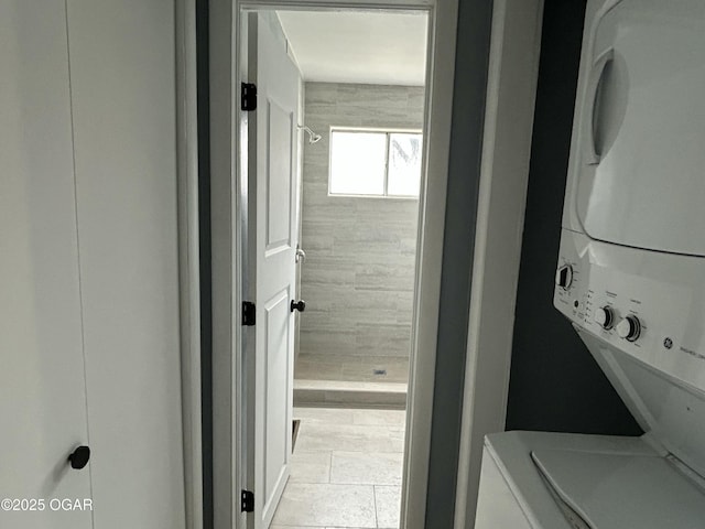 laundry area featuring stacked washer / drying machine and laundry area