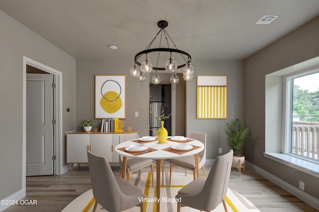 dining space featuring light hardwood / wood-style flooring and an inviting chandelier