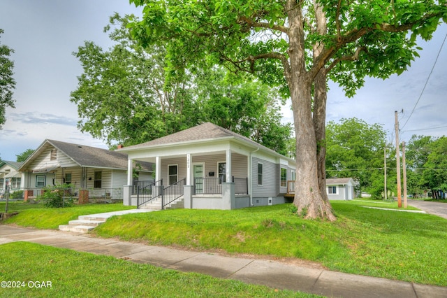 bungalow with covered porch and a front yard