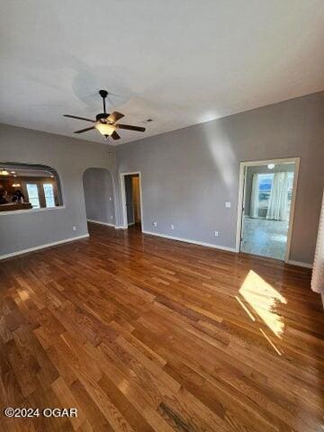 unfurnished living room featuring ceiling fan and dark hardwood / wood-style floors