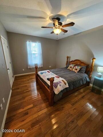 bedroom with dark wood-type flooring and ceiling fan