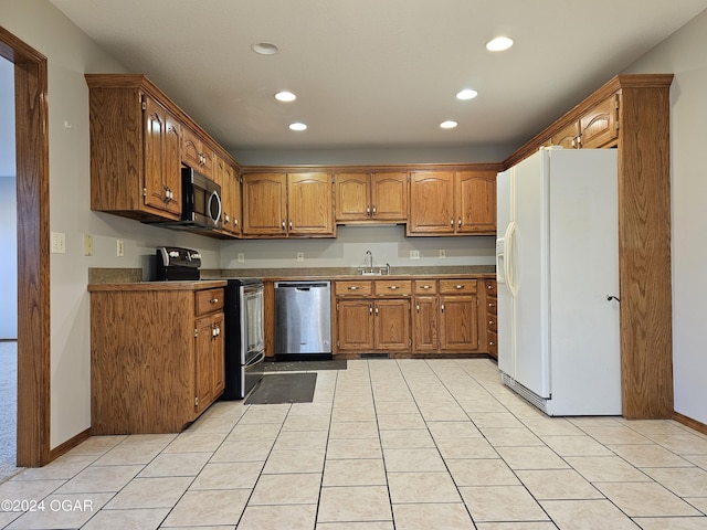 kitchen with sink, light tile patterned floors, and stainless steel appliances