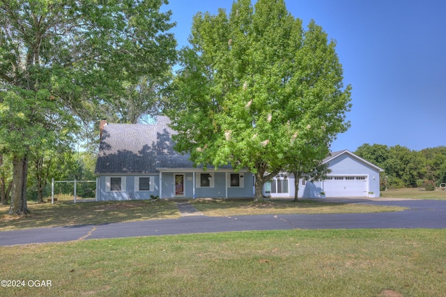 9825 County Rd 215, Webb City, MO 64870 - view of front of home featuring driveway, a front yard, a chimney, and an attached garage