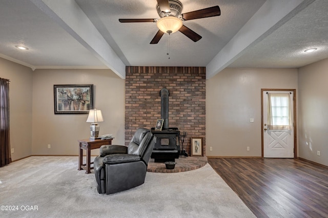 9825 County Rd 215, Webb City, MO 64870 - living room featuring a wood stove, baseboards, ceiling fan, a textured ceiling, and wood finished floors