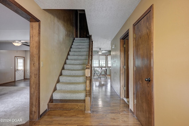 9825 County Rd 215, Webb City, MO 64870 - stairs featuring a ceiling fan, healthy amount of natural light, a textured ceiling, and wood finished floors