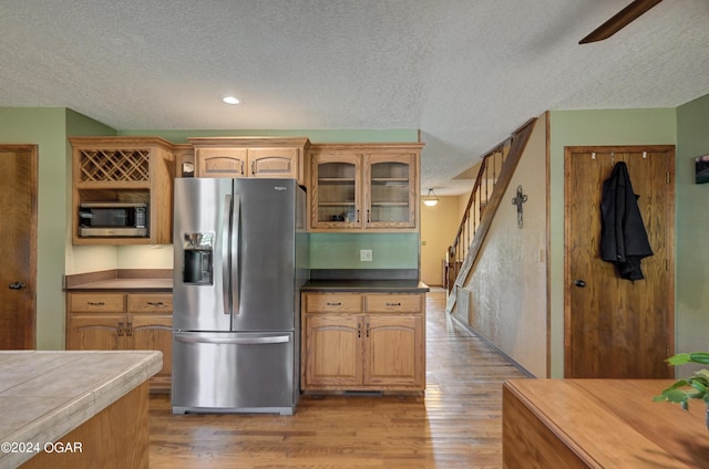 9825 County Rd 215, Webb City, MO 64870 - kitchen featuring stainless steel appliances, a textured ceiling, light wood-style flooring, a ceiling fan, and glass insert cabinets