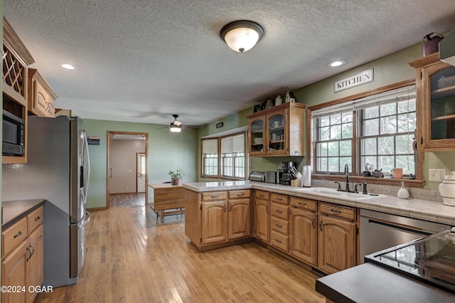 9825 County Rd 215, Webb City, MO 64870 - kitchen featuring a sink, a textured ceiling, stainless steel appliances, ceiling fan, and a peninsula