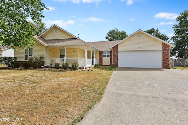 view of front of home with a garage, a porch, and a front lawn