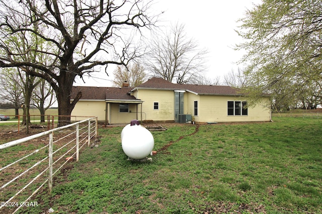 back of property with a lawn and central air condition unit