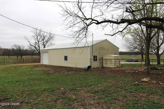 view of side of property featuring a lawn and an outbuilding