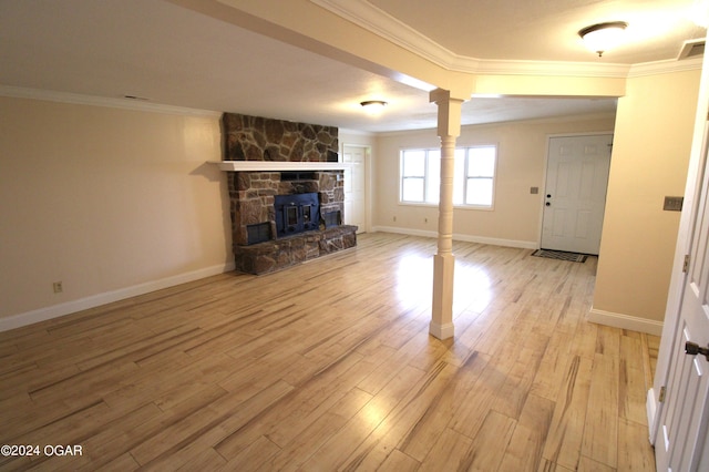 unfurnished living room with ornamental molding, light hardwood / wood-style floors, and a stone fireplace