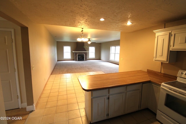 kitchen featuring a chandelier, a textured ceiling, electric stove, kitchen peninsula, and light carpet