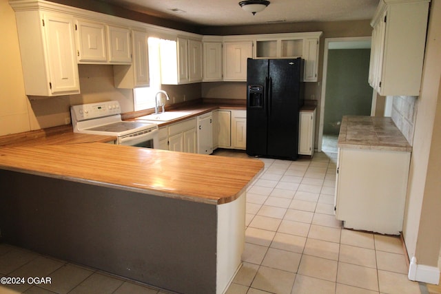 kitchen with kitchen peninsula, light tile patterned floors, white electric stove, sink, and black fridge