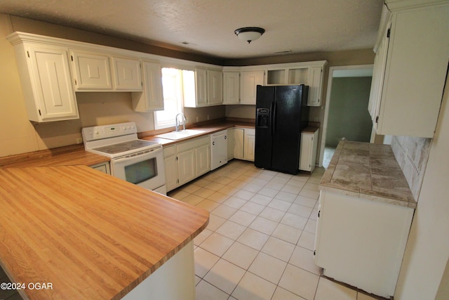 kitchen with electric stove, black fridge with ice dispenser, white cabinetry, and sink