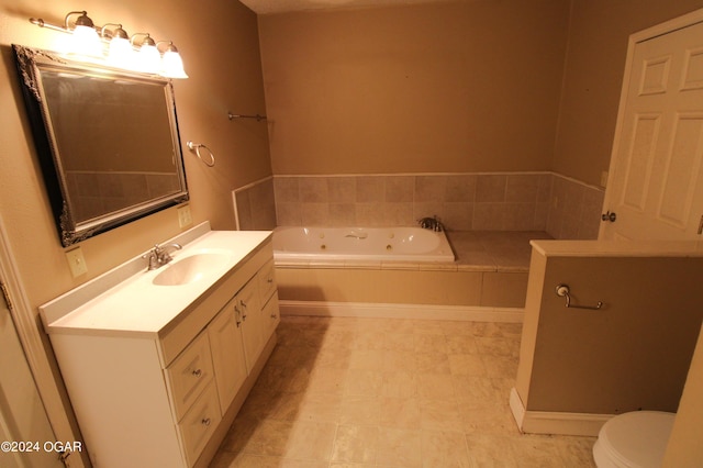 bathroom with tiled bath, vanity, and toilet