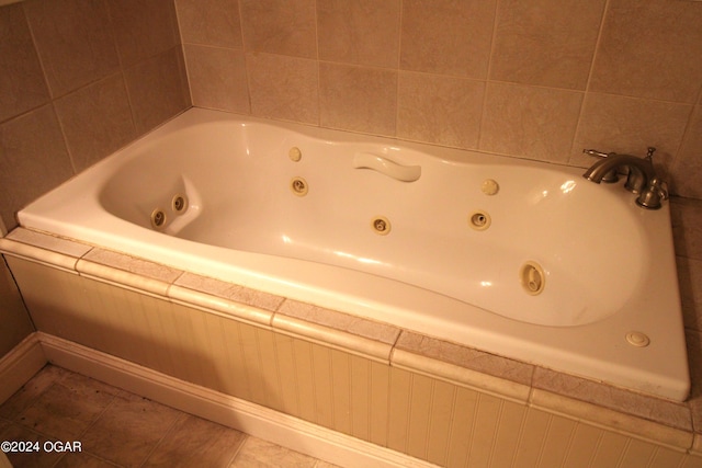 bathroom with tile patterned floors and a relaxing tiled tub