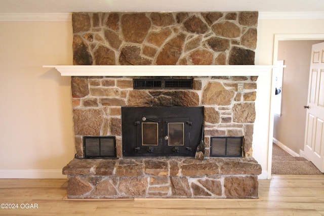 interior details featuring ornamental molding, a fireplace, and hardwood / wood-style floors