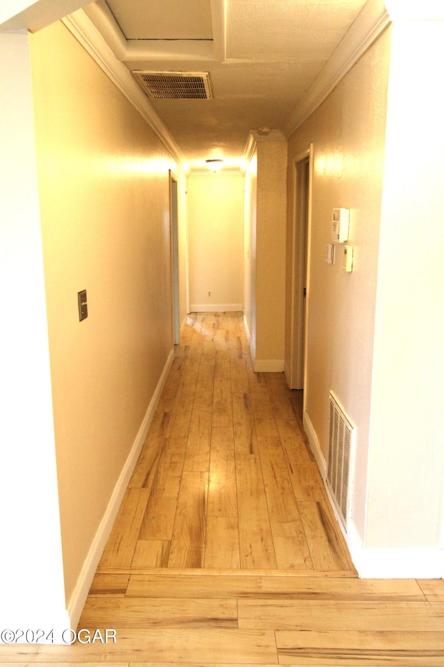 hallway featuring hardwood / wood-style floors and crown molding