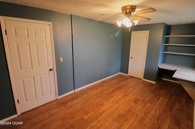 unfurnished bedroom with a textured ceiling, wood-type flooring, and ceiling fan