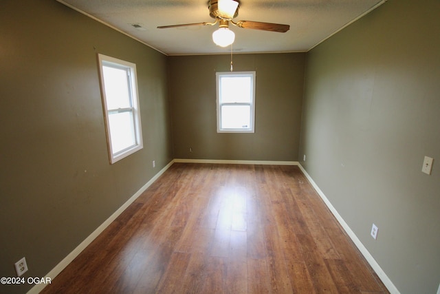 empty room with a textured ceiling, crown molding, ceiling fan, and hardwood / wood-style flooring